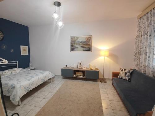 a bedroom with a bed and a couch at HARBOR house in Kavála