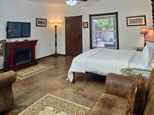 a bedroom with a bed and a fireplace and a tv at Fredericksburg Escape Wineries & Hot Tub in Fredericksburg