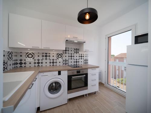une cuisine blanche avec un lave-linge et un sèche-linge. dans l'établissement Appartement tout équipé avec parking, à Marseille