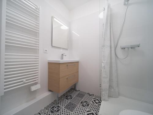 une salle de bain blanche avec un lavabo et un miroir dans l'établissement Appartement tout équipé avec parking, à Marseille