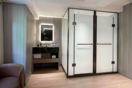 a bathroom with a sliding glass door with a sink at Chengdu Dafang Hotel 大方酒店 in Chengdu