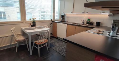a kitchen with a counter and a table with chairs at Midtown Jeppis in Pietarsaari