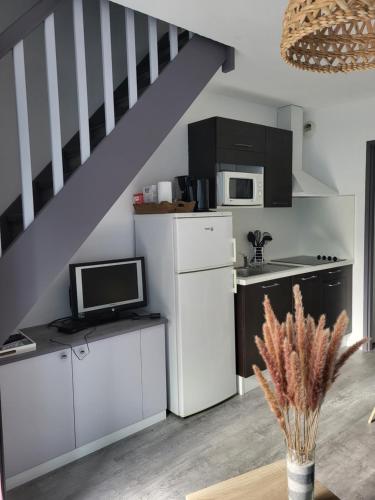 une cuisine avec des placards blancs et un escalier dans l'établissement Terrasses du lac appt, à Aureilhan