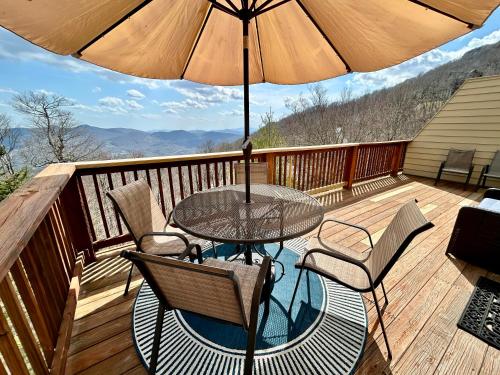a table and chairs on a deck with an umbrella at The Summit in Banner Elk