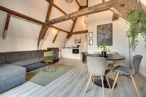 a living room with a couch and a table and chairs at The Dam Apartments in Middelburg