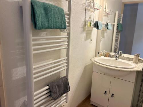 une salle de bain blanche avec un lavabo et un miroir dans l'établissement Villa Roussillon, à Torreilles