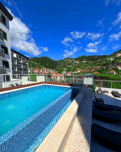 a swimming pool on the side of a building at A SELVA T2 in Caniço in Caniço