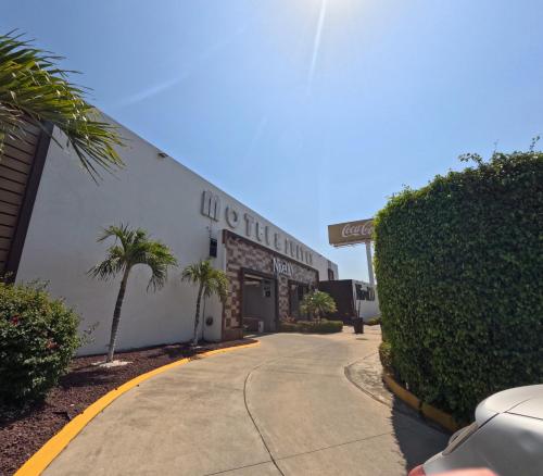 a building with a car parked in front of it at Hotel Motel Nivel 10 in Manzanillo