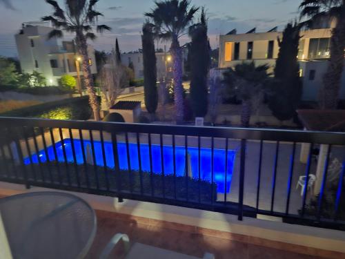 a balcony with a view of a pool with palm trees at Sunset Green 02 in Paphos City