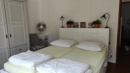 une chambre avec deux lits avec des oreillers blancs dans l'établissement Beach holiday in Argeles-sur-mer, with pool, à Argelès-sur-Mer