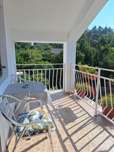 a patio with a table and a chair on a balcony at Savo Apartments in Tivat