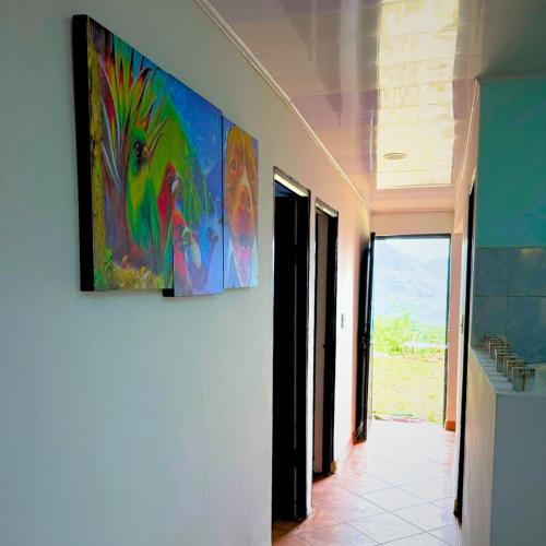 a painting hanging on a wall in a hallway at Casa la Colina in Macanal