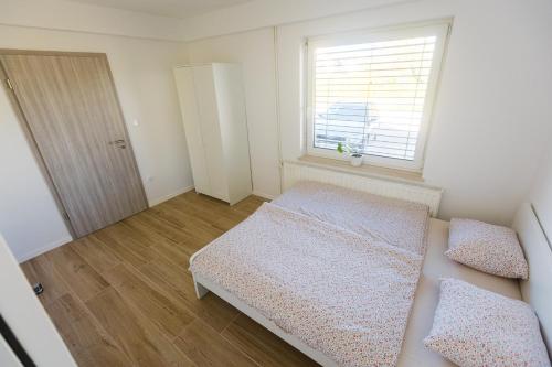 a small bedroom with a bed and a window at Apartma Tom in Metlika