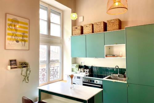 une cuisine avec des armoires vertes et une table à l'intérieur dans l'établissement Le Canut - Croix-Rousse - proche métro C, à Lyon