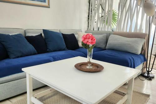 - une table basse blanche avec un vase de fleurs dans l'établissement Family house of 92 m2 with terrace - Cabourg, à Cabourg