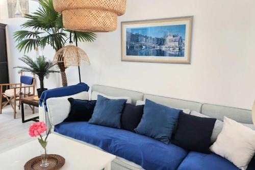 un salon avec un canapé bleu et une table dans l'établissement Family house of 92 m2 with terrace - Cabourg, à Cabourg