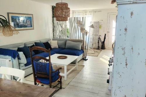 un salon avec un canapé bleu et une table dans l'établissement Family house of 92 m2 with terrace - Cabourg, à Cabourg