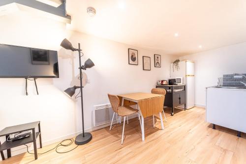 un salon avec une table et une télévision dans l'établissement Le Cosmo - Cosy appart 2 pers-Brotteaux-Métro B, à Lyon