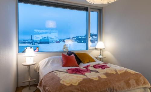 a bedroom with a bed with a large window at ArticVieW Tromsø city centre in Tromsø