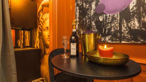 - une table avec une bouteille de vin et une bougie dans l'établissement La Clé des Sens Votre Love Room en Journée, à Troyes
