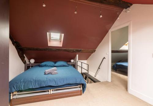 une chambre avec un lit bleu et un miroir dans l'établissement Appartement 3 Pieces Hôtel de Ville Paris, à Paris