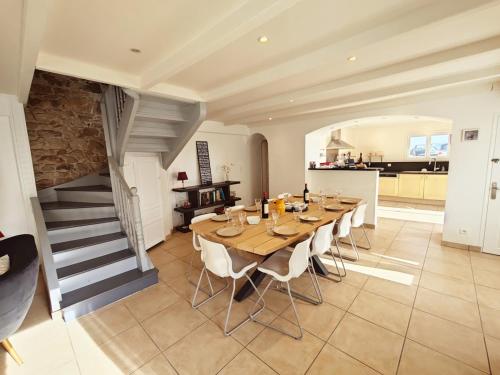 une grande salle à manger avec une table et des chaises en bois dans l'établissement Kervéguen Family home, à Plougoulm