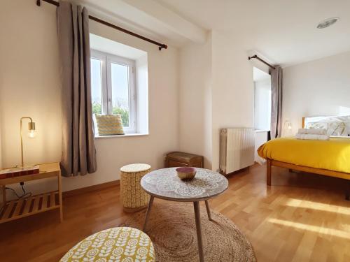 une chambre avec un lit jaune et une table dans l'établissement Kervéguen Family home, à Plougoulm
