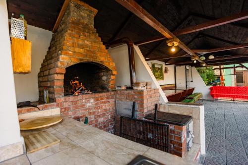 a brick fireplace in a living room with a couch at Pensiunea Silva Home in Luncaviţa