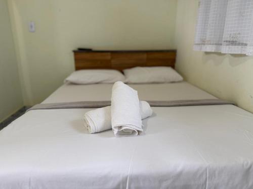 two beds with white sheets and towels on them at Pousada Tortuga in Anchieta