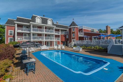 a swimming pool in front of a large house at Inn on the Lake in Fall River