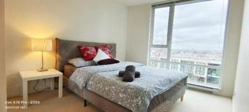 ein Schlafzimmer mit einem Bett, auf dem ein Teddybär liegt in der Unterkunft Fabulous and convenient 2B2B close to Richmond center in Richmond