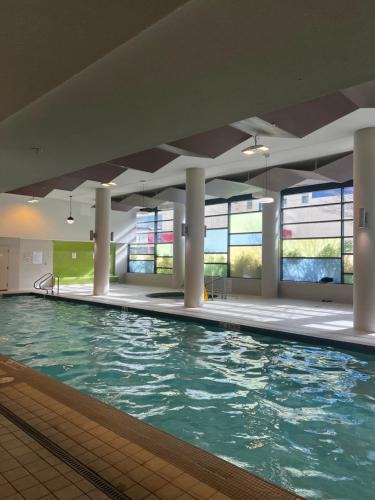 a swimming pool with blue water in a building at Fabulous and convenient 2B2B close to Richmond center in Richmond