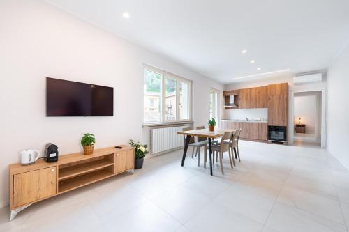 a kitchen and dining room with a table and a tv at Borgo Trento Residence in Verona