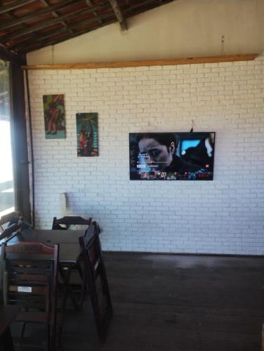 a wall with a tv on a brick wall at Pousada Capitão in Barra do Sirinhaém