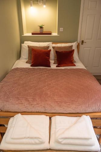 a large bed with white sheets and red pillows at Walker's Rest in Newland