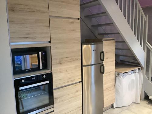 - une cuisine avec un réfrigérateur en acier inoxydable à côté d'un escalier dans l'établissement Charmante maison située à 150 m de la plage, à Plérin