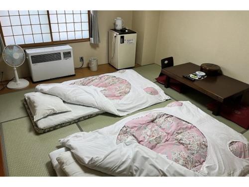 two beds in a room with a table and a table at Kitaguni Grand Hotel - Vacation STAY 97233v in Oshidomari