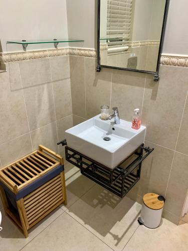 a bathroom with a white sink and a mirror at Tranquillity within the forest in Southbroom