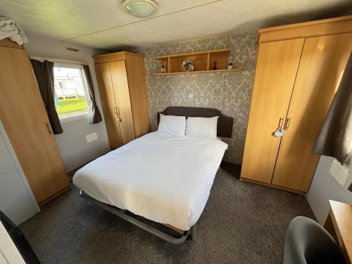 a small bedroom with a bed with white sheets at Meadow View 158 - Golden Palm, Pet friendly, WiFi, bed linen - Meadow Lakes Caravan & Lodge Hire in Skegness