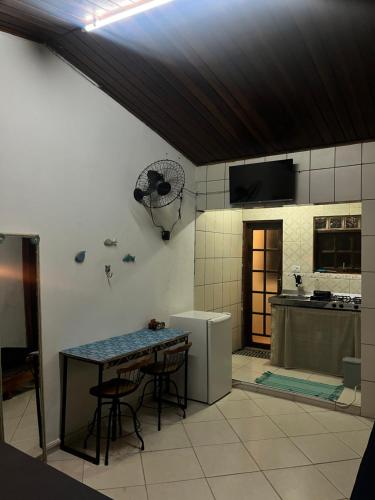 une cuisine avec une table et un réfrigérateur dans l'établissement Kitnet Boraceia mar e sol, à Bertioga