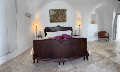 Un dormitorio con una gran cama de madera en una habitación. en Al numero 13, en Martina Franca
