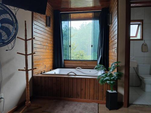 una vasca da bagno in una stanza con una finestra di Casa Visconde 2 a Visconde De Maua