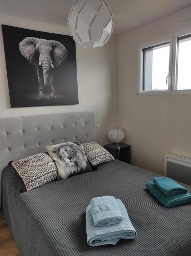 une chambre avec un lit avec une photo d'éléphant sur le mur dans l'établissement maison au calme avec piscine proche de l'ocean, à Erdeven