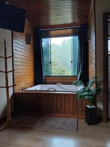 una vasca da bagno in una stanza con una finestra di Casa Visconde 2 a Visconde De Maua