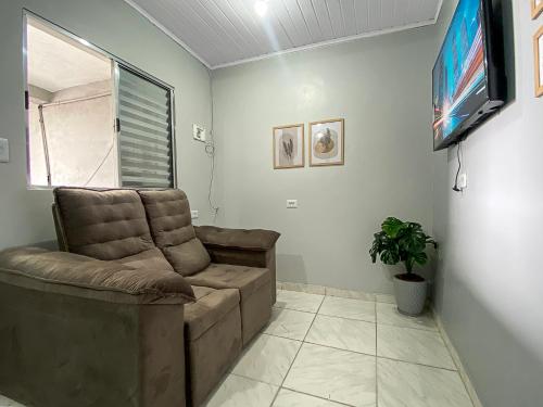 a living room with a couch and a flat screen tv at Economic Central 1 Bedroom Full Kitchen in Carapicuíba