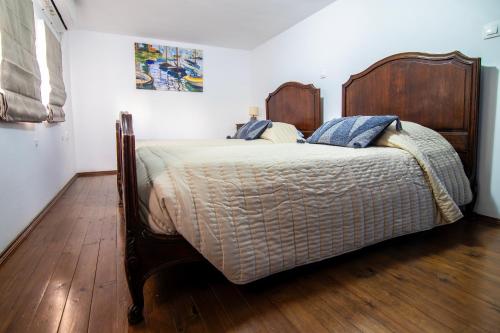 a bedroom with a large bed with a wooden headboard at Nostalgia Suites in Faliraki