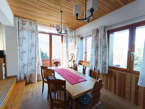 d'une salle à manger avec une table et quelques fenêtres. dans l'établissement Résidence Le Panoramix - Très bel appartement cosy dans un chalet face au Janus MAE-4511, à Montgenèvre