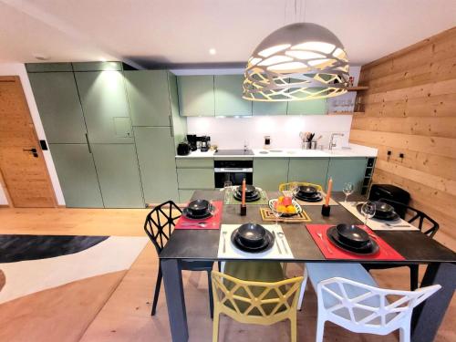 une cuisine avec une table et des chaises dans une pièce dans l'établissement Résidence Flocon Bleu - Appartement de Charme, confort, proximité centre MAE-4591, aux Gets