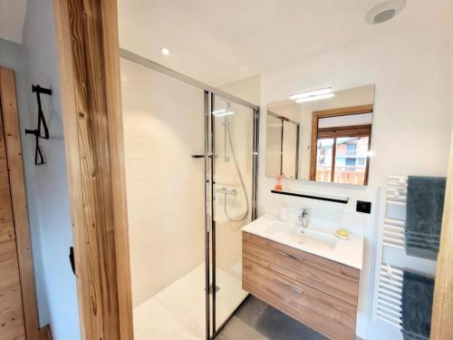 une salle de bain avec douche et lavabo dans l'établissement Résidence Flocon Bleu - Appartement de Charme, confort, proximité centre MAE-4591, aux Gets