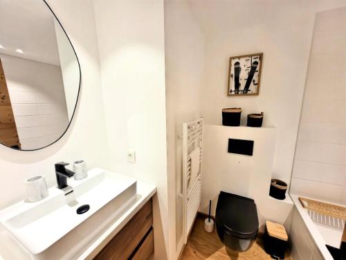 une salle de bain avec un lavabo et un miroir dans l'établissement Résidence Flocon Bleu - Un cocon de standing au cœur des Gets MAE-4601, aux Gets
